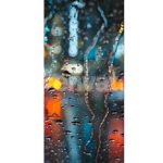 Lights of the Evening City and Passing Cars Through a Wet Rainy Window